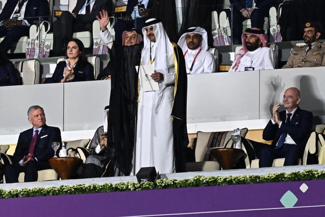 Qatar's Emir Sheikh Tamim bin Hamad al-Thani waves prior to delivering a speech next to Abdullah II King of Jordan and FIFA President Gianni Infantino during the opening ceremony.
