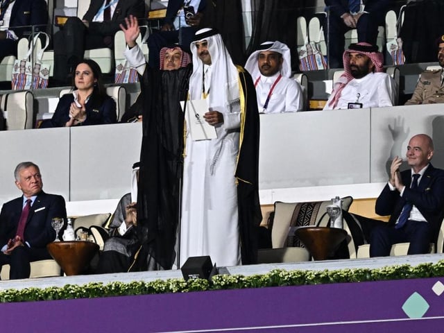 Qatar's Emir Sheikh Tamim bin Hamad al-Thani waves prior to delivering a speech next to Abdullah II King of Jordan and FIFA President Gianni Infantino during the opening ceremony.