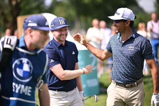 Connor Syme is congratulated by playing partner Rafa Cabrera Bello after making the first hole-in-one of his DP World Tour career. Picture: Stuart Franklin/Getty Images.
