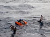 A woman tries to board a rescue boat in the Mediterranean Sea after her vessel sank, with the deaths of five people, including a new-born child (Picture: Alessio Paduano/AFP via Getty Images)