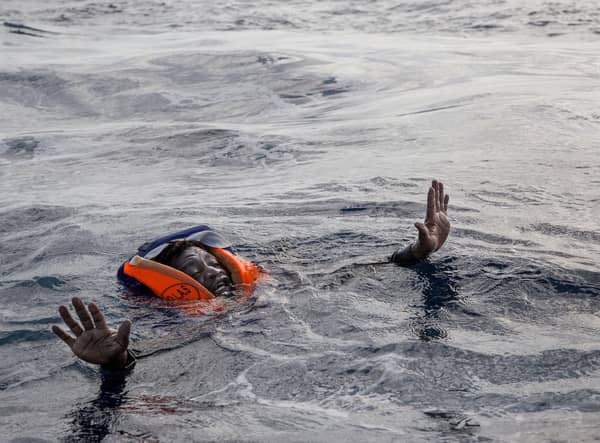 A woman tries to board a rescue boat in the Mediterranean Sea after her vessel sank, with the deaths of five people, including a new-born child (Picture: Alessio Paduano/AFP via Getty Images)