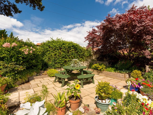 Exterior: The front and back gardens are colourful and well maintained, and there is a patio, driveway and garage.
