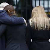 Prince Andrew, Duke of York puts his arm around Princess Eugenie of York and Princess Beatrice of York