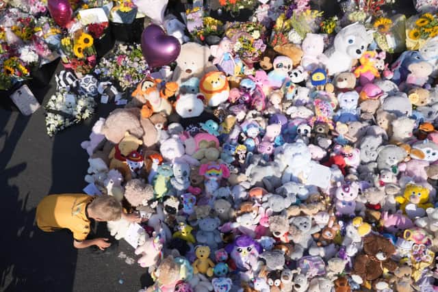 People look at floral tributes on Maple Street, Southport. Picture: Danny Lawson/PA Wire