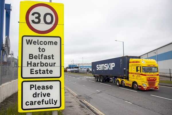 A haulage lorry driving passed a sign at Belfast Port, as The Northern Ireland Protocol has created a "feast or famine" economy in the region with some businesses struggling while others thrive, a parliamentary report has found.