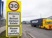 A haulage lorry driving passed a sign at Belfast Port, as The Northern Ireland Protocol has created a "feast or famine" economy in the region with some businesses struggling while others thrive, a parliamentary report has found.