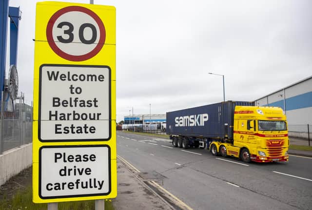A haulage lorry driving passed a sign at Belfast Port, as The Northern Ireland Protocol has created a "feast or famine" economy in the region with some businesses struggling while others thrive, a parliamentary report has found.