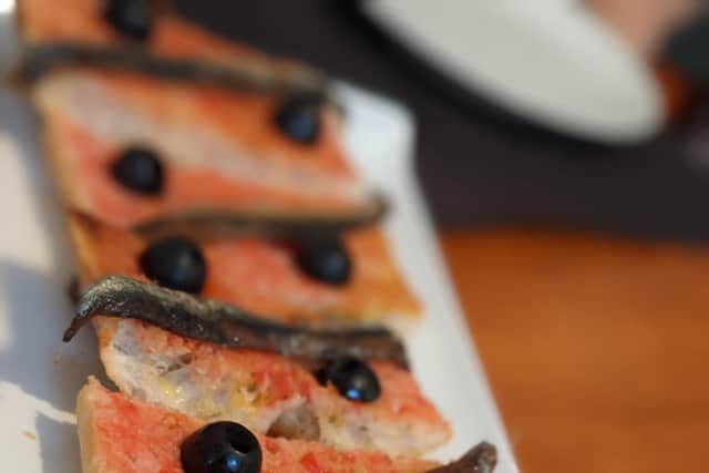 A slice of Spanish toast, painted with tomato instead of butter and topped with local anchovies, at Bau Bar, Girona.