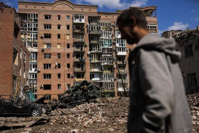 A man walks next to heavily damaged buildings and destroyed cars following Russian attacks in Bakhmut, Donetsk region, eastern Ukraine, Tuesday, May 24, 2022. The region, along with neighbouring Luhansk, is part of the Donbas, where Russian forces have focused their offensive. (AP Photo/Francisco Seco)