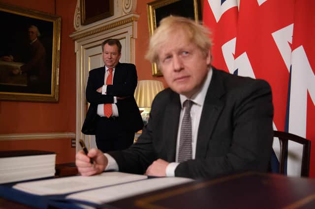 (FILES) In this file photo taken on December 30, 2020 UK chief trade negotiator, David Frost (L) looks on as Britain's Prime Minister Boris Johnson signs the Trade and Cooperation Agreement between the UK and the EU, the Brexit trade deal, at 10 Downing Street in central London. - The UK government on July 21, 2021 demanded the EU re-negotiate post-Brexit trading arrangements for Northern Ireland after rioting and business disruption hit the restive province. (Photo by Leon Neal / POOL / AFP) (Photo by LEON NEAL/POOL/AFP via Getty Images)