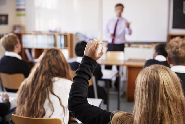 A student raises their hand to ask a question in class. Picture: Getty Images