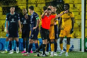 Referee Grant Irvine checks VAR which shows an offside before the foul by Hibs' Paul Hnalon on Livingston's Mo Sangare.