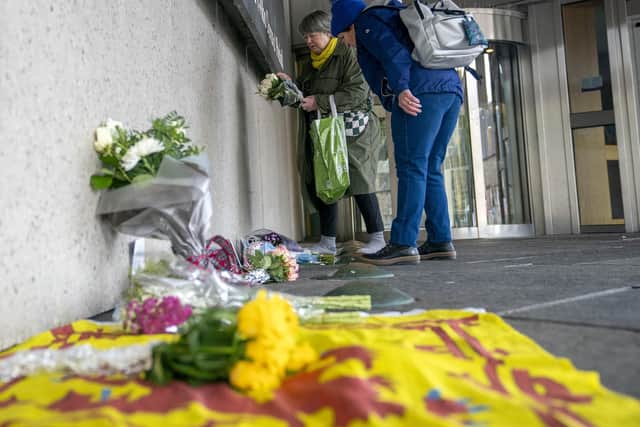 Members of the public place flowers outside the Scottish Parliament in Edinburgh after Alex Salmond died aged 69.