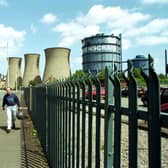 Two men walk through the gates of Ravenscraig steel works aster the last shift before the plant finally closes in June 1992.