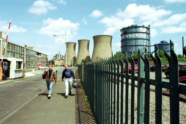 Two men walk through the gates of Ravenscraig steel works aster the last shift before the plant finally closes in June 1992.