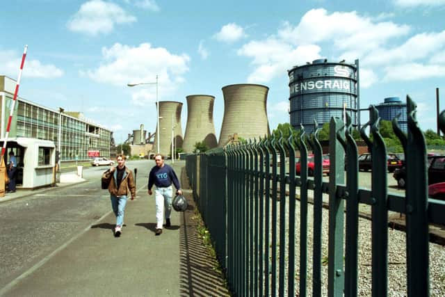 Two men walk through the gates of Ravenscraig steel works aster the last shift before the plant finally closes in June 1992.