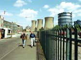 Two men walk through the gates of Ravenscraig steel works aster the last shift before the plant finally closes in June 1992.