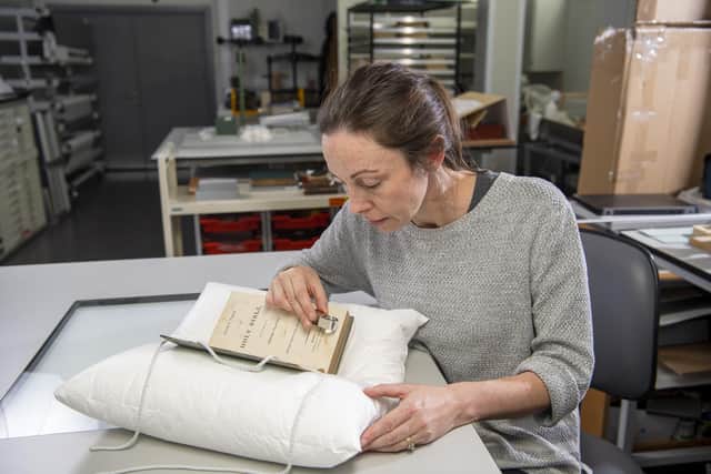 Keira McKee, a book conservator at University of Glasgow, with the early 19th Century 'slave bible'. PIC: University of Glasgow.