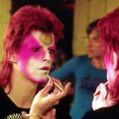 David Bowie applying his Ziggy Stardust makeup in the 1970s. Picture: R Bamber/Rex Features