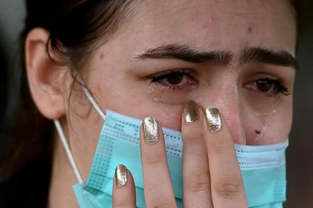 An Afghan woman living in India reacts outside the embassy of the United States of America in New Delhi (Photo by Money Sharma / AFP) (Photo by MONEY SHARMA/AFP via Getty Images)