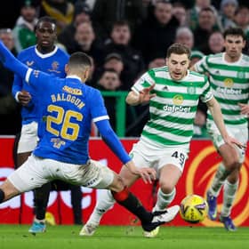 Celtic's James Forrest (R) goes past Rangers' Leon Balogun.