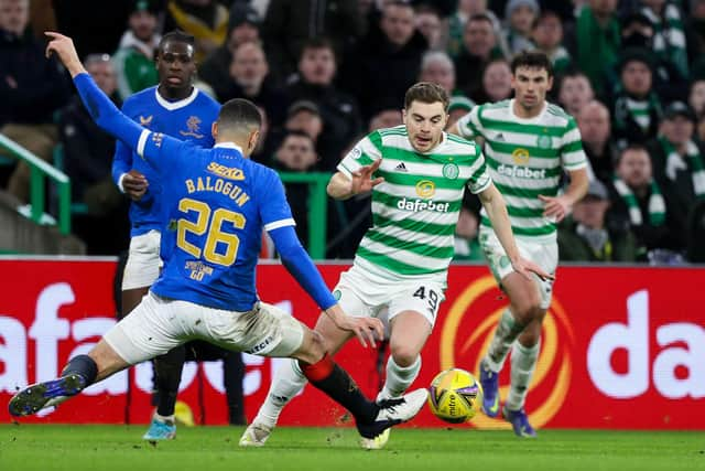 Celtic's James Forrest (R) goes past Rangers' Leon Balogun.