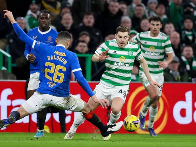 Celtic's James Forrest (R) goes past Rangers' Leon Balogun.