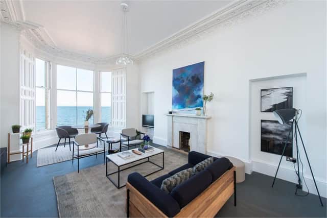 The bright living room has bay windows and a fireplace.