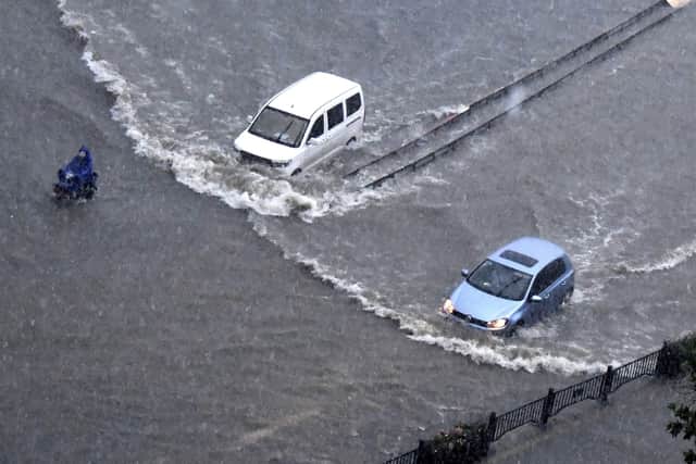Vehicles pass through floodwaters in Zhengzhou in central China's Henan Province (Zhu Xiang/Xinhua via AP)