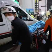 Rescuers move a victim after the stampede in Seoul's Itaewon district