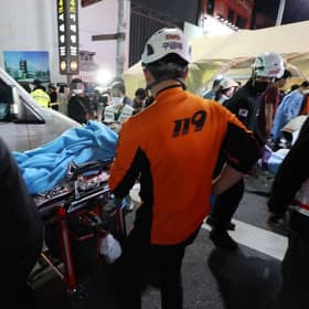 Rescuers move a victim after the stampede in Seoul's Itaewon district