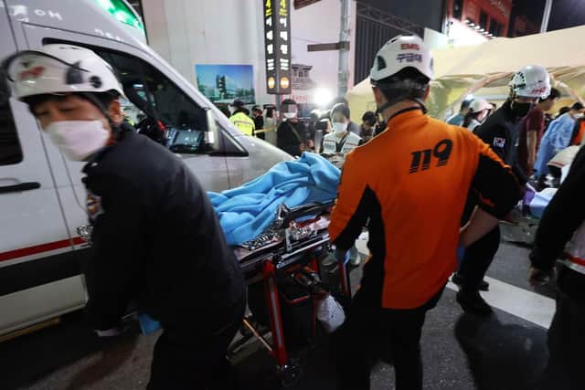 Rescuers move a victim after the stampede in Seoul's Itaewon district
