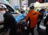 Rescuers move a victim after the stampede in Seoul's Itaewon district