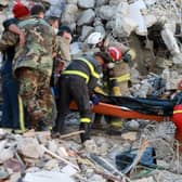 Rescuers carry a victim retrieved from the rubble of a collapsed building, in the regime-controlled town of Jableh in the province of Latakia, northwest of the Syrian capital Damascus.