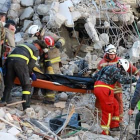 Rescuers carry a victim retrieved from the rubble of a collapsed building, in the regime-controlled town of Jableh in the province of Latakia, northwest of the Syrian capital Damascus.