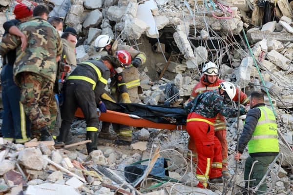 Rescuers carry a victim retrieved from the rubble of a collapsed building, in the regime-controlled town of Jableh in the province of Latakia, northwest of the Syrian capital Damascus.