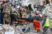 Rescuers carry a victim retrieved from the rubble of a collapsed building, in the regime-controlled town of Jableh in the province of Latakia, northwest of the Syrian capital Damascus.