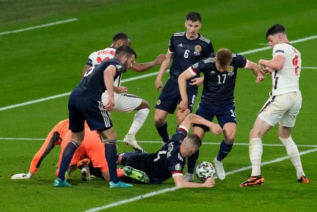 Scotland's Scott McTominay and Stuart Armstrong scramble the ball with Declan Rice of England.