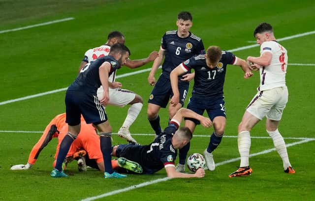 Scotland's Scott McTominay and Stuart Armstrong scramble the ball with Declan Rice of England.