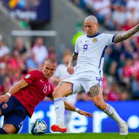 Lyndon Dykes nips ahead of Norway defender Leo Skiri Ostigard to net Scotland's equaliser. (Photo by FREDRIK VARFJELL/NTB/AFP via Getty Images)