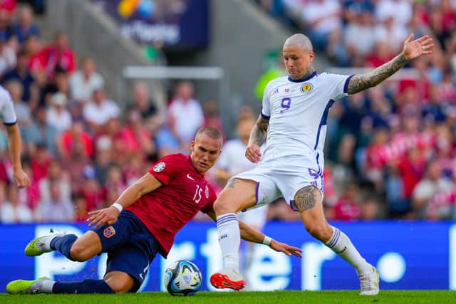 Lyndon Dykes nips ahead of Norway defender Leo Skiri Ostigard to net Scotland's equaliser. (Photo by FREDRIK VARFJELL/NTB/AFP via Getty Images)