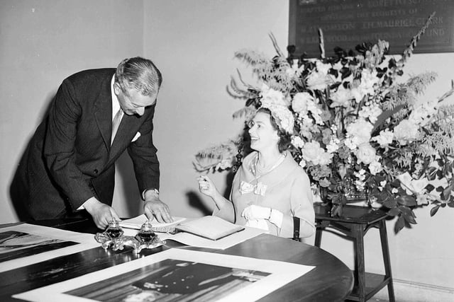Queen Elizabeth II signs the visitors' book of Loretto School, alongside headmaster Mr David Forbes Mackintosh, on July 1, 1958.
