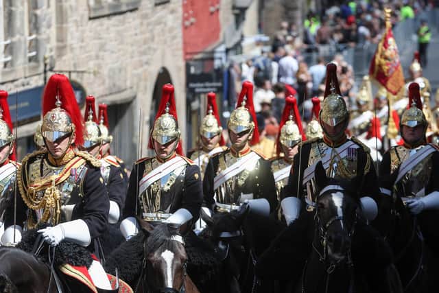 Members of the military make their way down the Royal Mile to St Giles' Cathedral