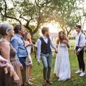 A bride, groom and their guests at the wedding reception outside