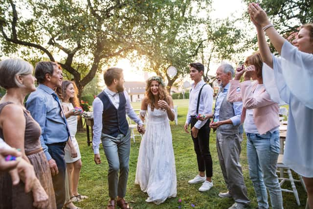 A bride, groom and their guests at the wedding reception outside