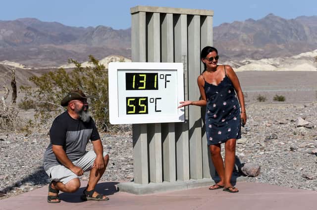 People gather for a photo in front of an unofficial thermometer at Furnace Creek Visitor Centre in Death Valley National Park, California. Park visitors were warned to travel 'prepared to survive'. (Picture: Mario Tama/Getty Images)