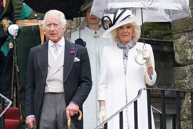 King Charles III and Britain's Queen Camilla pause for the National Anthem, as they host guests for a Garden Party at the Palace of Holyroodhouse in Edinburgh. Picture: Jonathan Brady/POOL/AFP via Getty Images