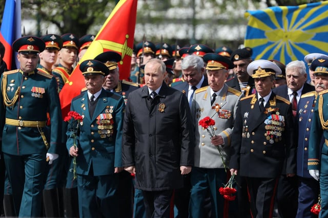 Russian President Vladimir Putin attends a flower-laying ceremony at the Tomb of the Unknown Soldier after the Victory Day military parade in central Moscow. Photo by Anton Novoderezhkin via Getty Images)