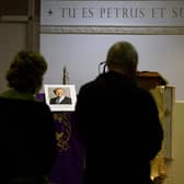 A photograph of David Amess is displayed as people wait for the start of a mass at Saint Peter's Catholic Parish of Eastwood in Leigh-on-Sea