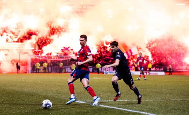 Rangers' Ryan Jack and Dundee's Owen Beck in action as flares light up the stands behind them.  (Photo by Ross Parker / SNS Group)
